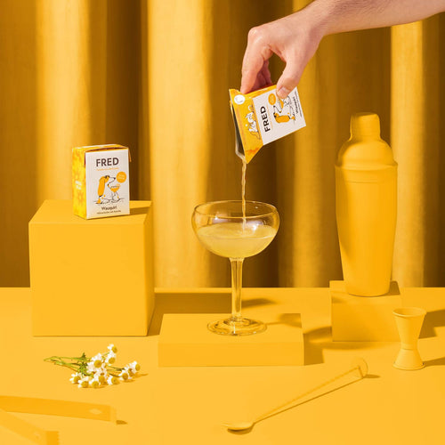Main versant la boisson dans une coupe, décor jaune