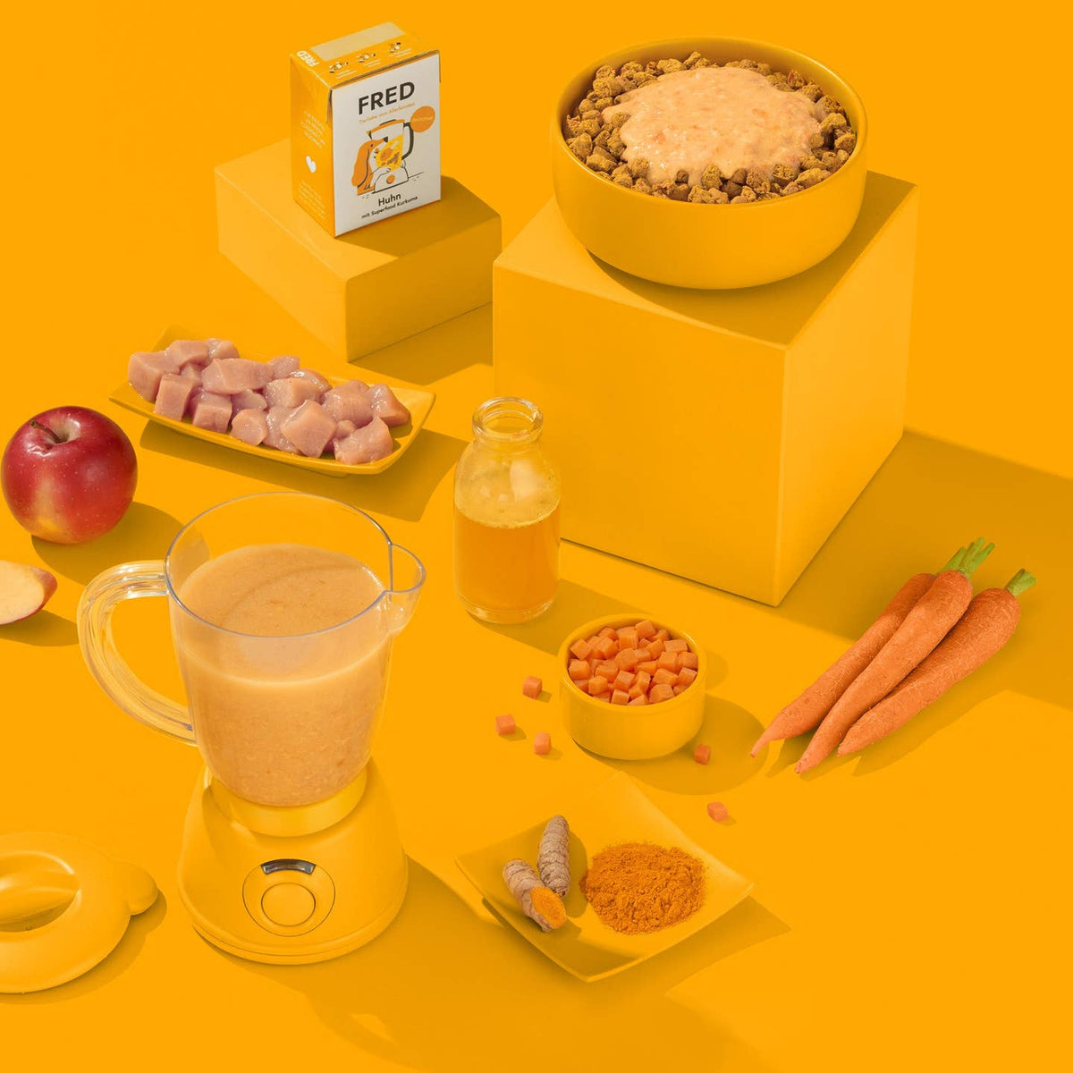 Brique, mixeur, carottes et pomme sur fond orange