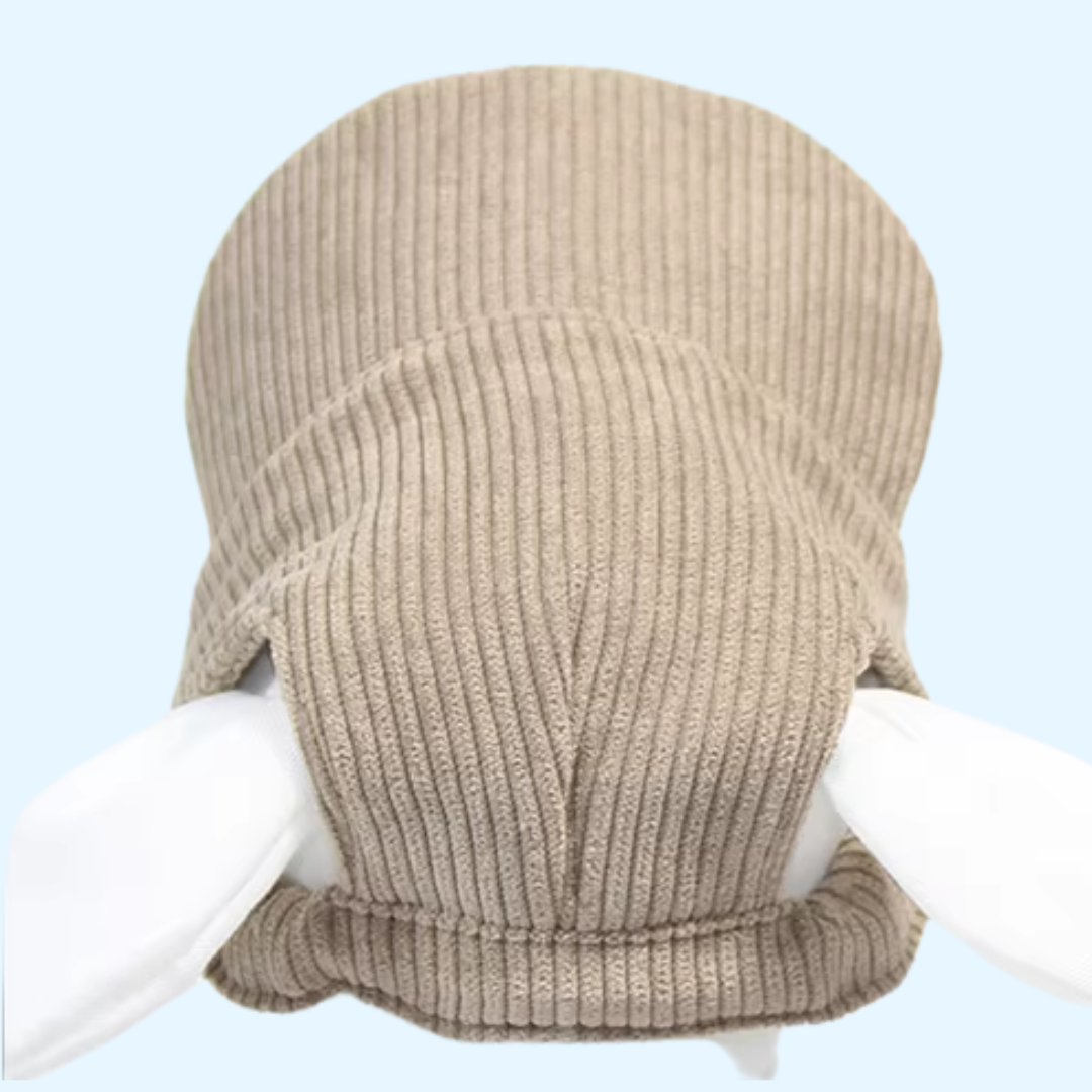Casquette beige tenue par deux mains, vue de dessus
