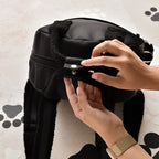 Mains ouvrant la poche arrière du sac noir