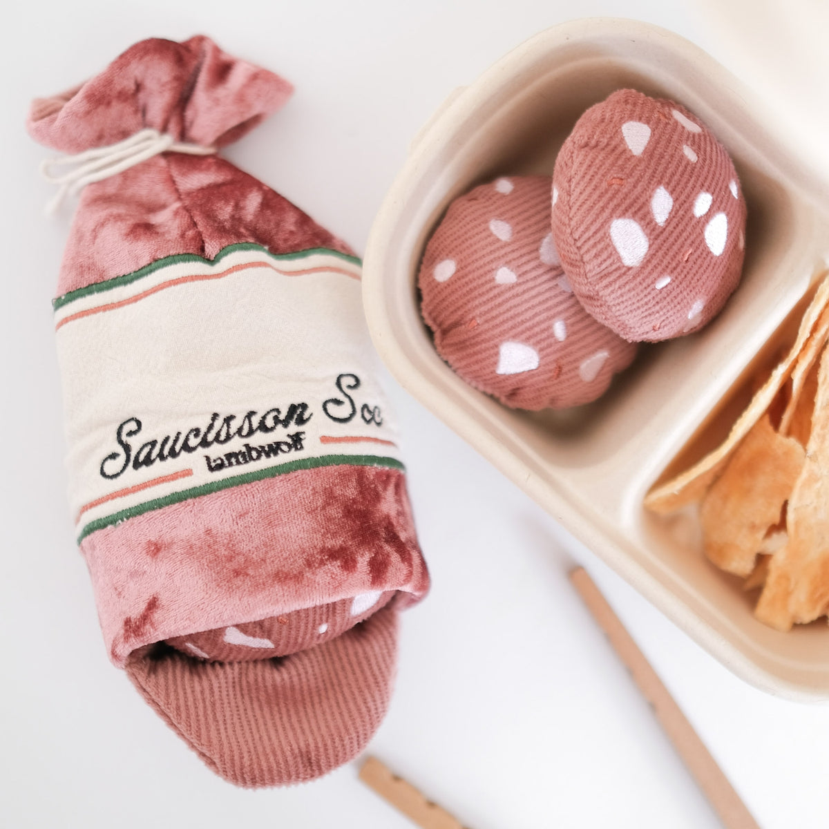 Saucisson en velours rose posé sur une planche avec rondelles