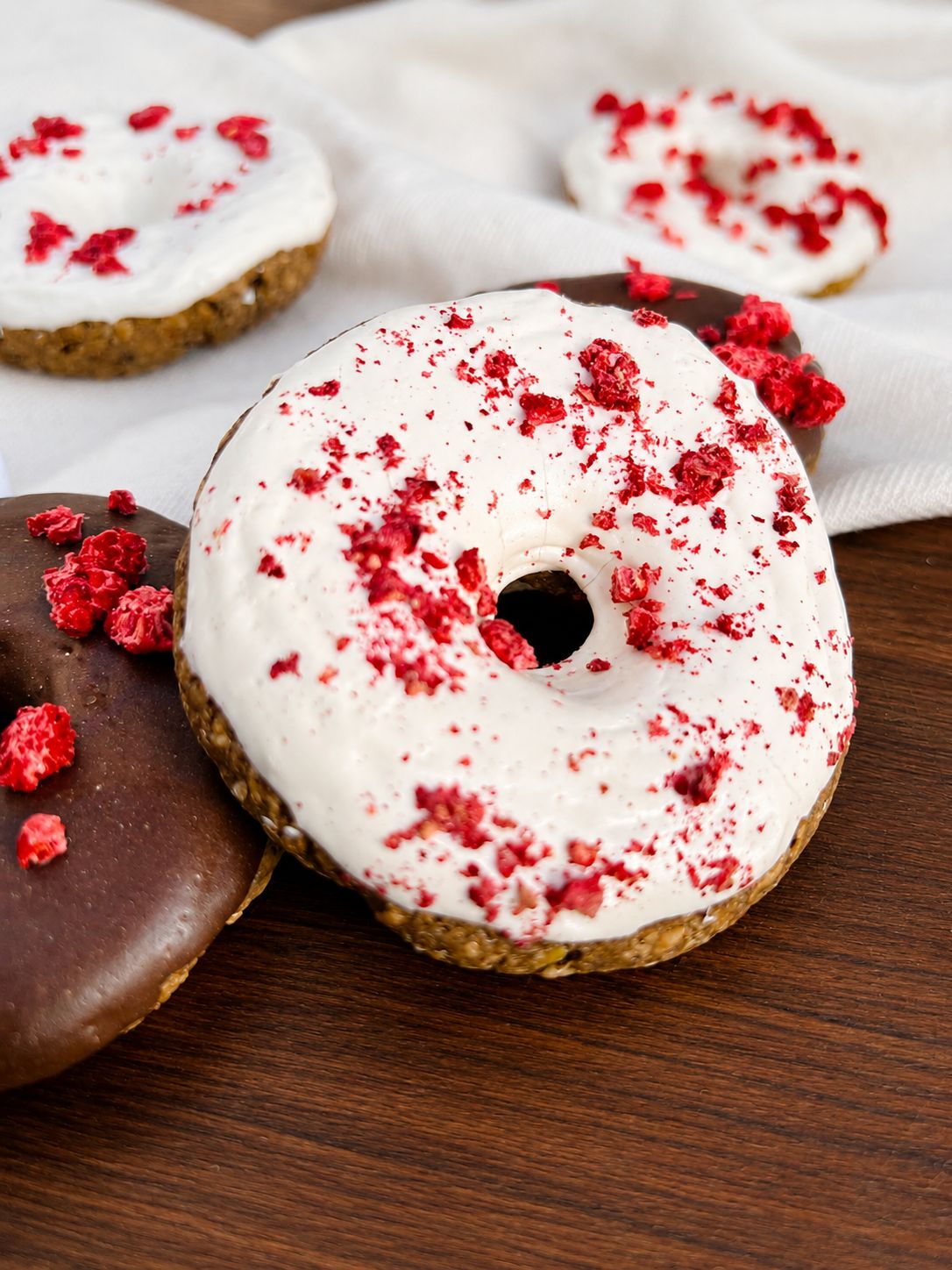 Gros plan sur un donut glaçage blanc et éclats de framboise