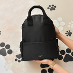 Sac noir tenu à la main sur fond d'empreintes