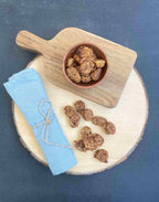 Friandises training Fresco lapin, pomme & chou frisé sur une planche en bois et dans un bol
