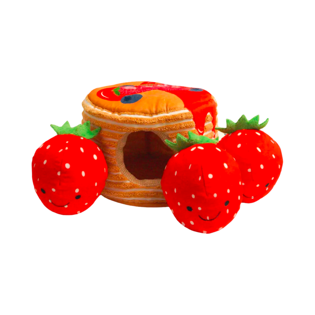 Pile de pancakes nappée avec trois fraises rouges souriantes