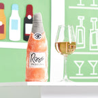 Peluche bouteille de rosé ZippyPaws à côté d'un verre de vin