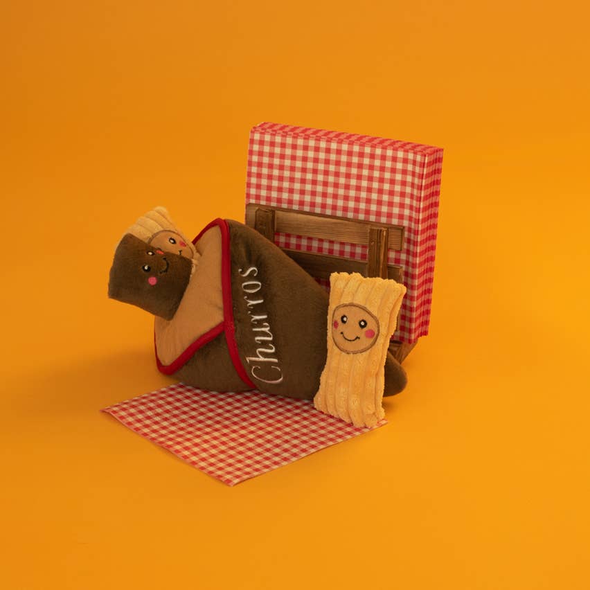 Cornet et churros posés devant une nappe à carreaux sur fond orange