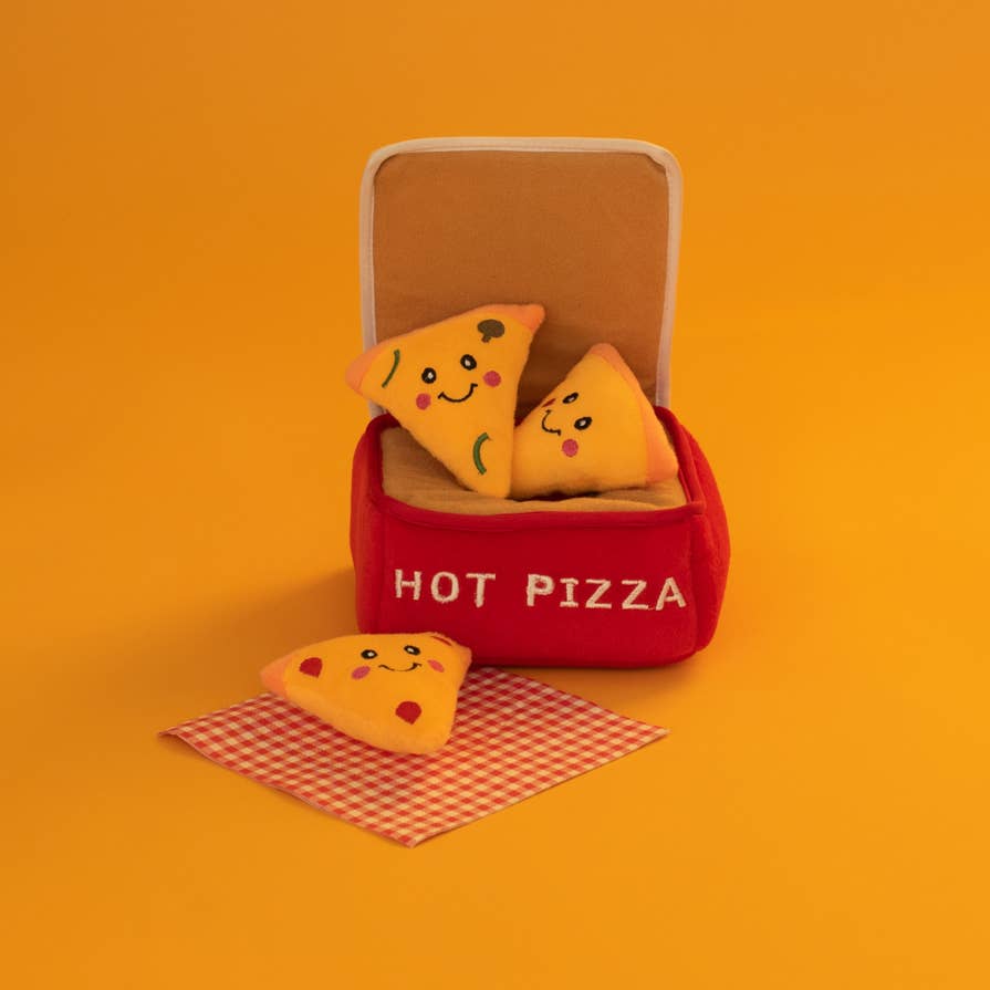 Boîte à pizza et ses parts posées sur fond orange
